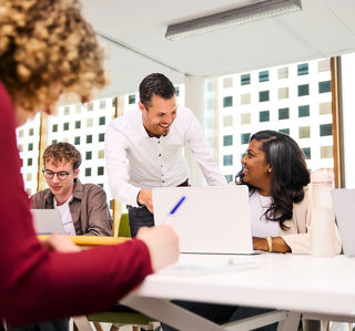 Docent helpt student en lacht